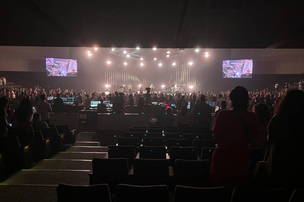 A large crowd watching a band perform on stage.
