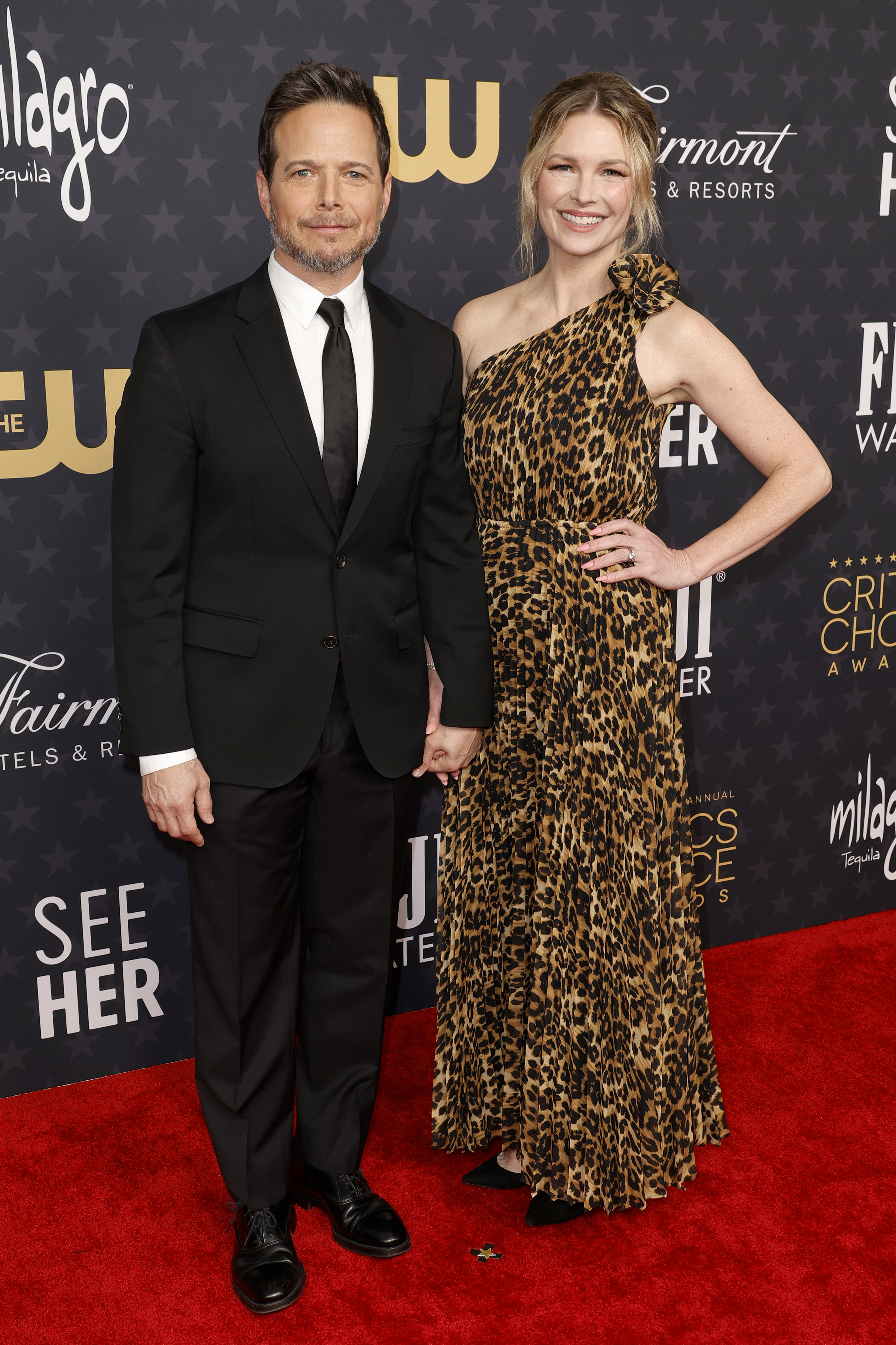 Scott and Kelley Wolf pose on a red carpet. 