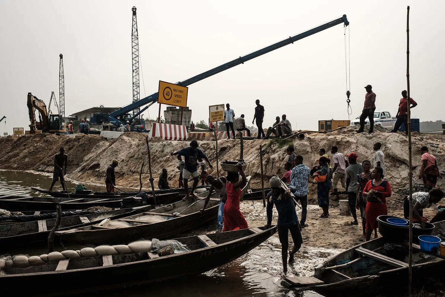 A bridge construction site near a river devastated by oil spills.