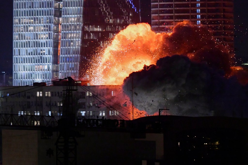 Explosion near buildings at night.