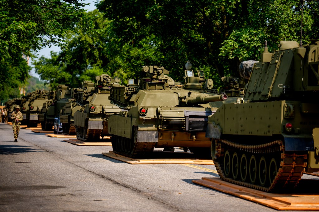Military vehicles lined up on a road.