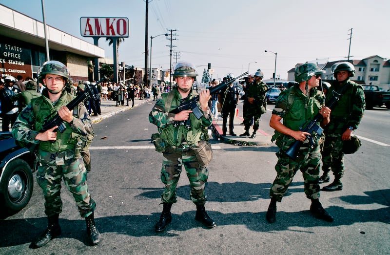 Armed National Guard soldiers hold a line in front of a post office in South Central Los Angeles on May 1, 1992. Los Angeles had undergone several days of rioting due to the acquittal of LAPD officers who beat Rodney King. Hundreds of businesses were burned to the ground and over 55 people have been killed.