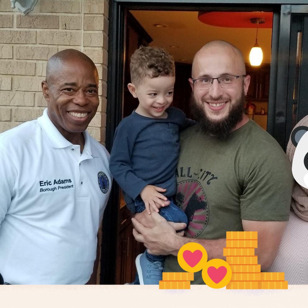 Eric Adams, Borough President, with Mohamed Bahi who is holding a small child.