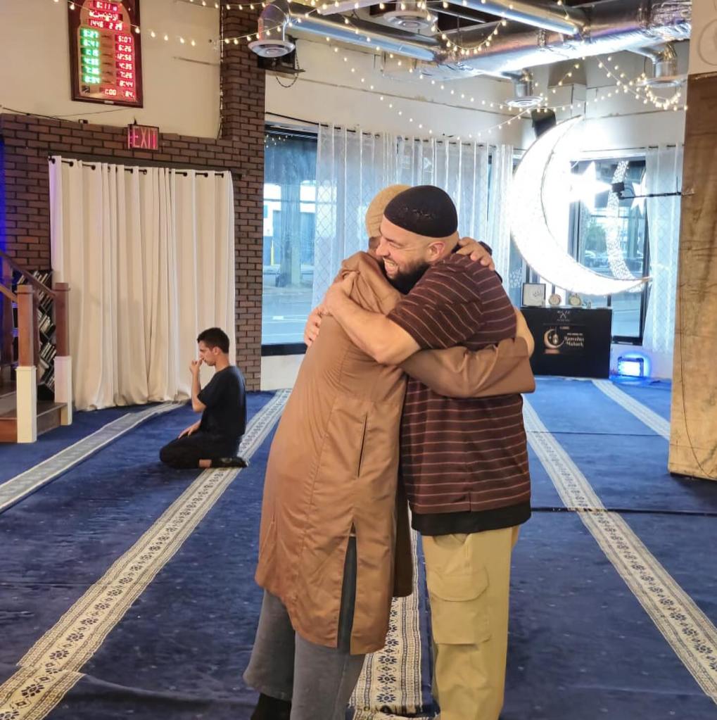 Two men hugging in a mosque.
