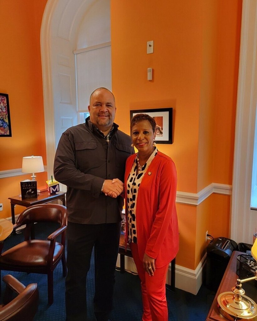 Adrienne Adams shaking hands with a man in her office.