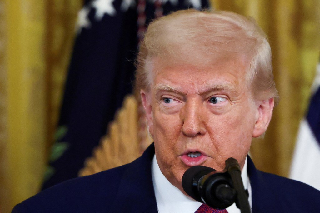President Trump speaking at a microphone at the White House.