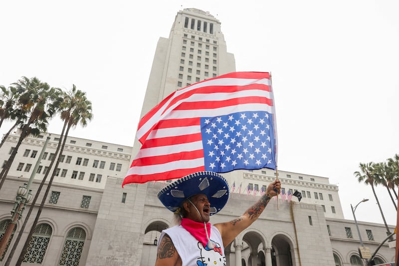 A person waves a U.S. flag upside down during a protest against federal immigration sweeps, in Los Angeles, California, U.S., June 14, 2025.