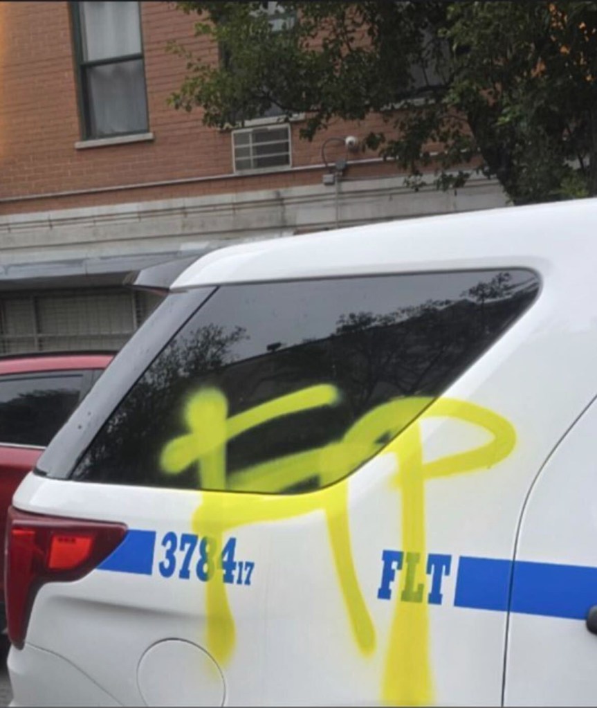 Graffiti on a damaged NYPD vehicle.