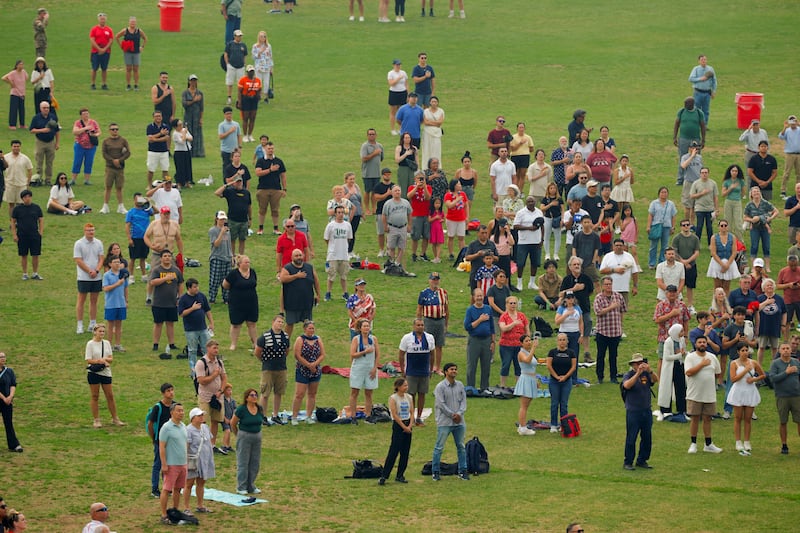 Attendees listen to the U.S. national anthem during the military parade commemorating the U.S. Army's 250th birthday in Washington, D.C., U.S., June 14, 2025.
