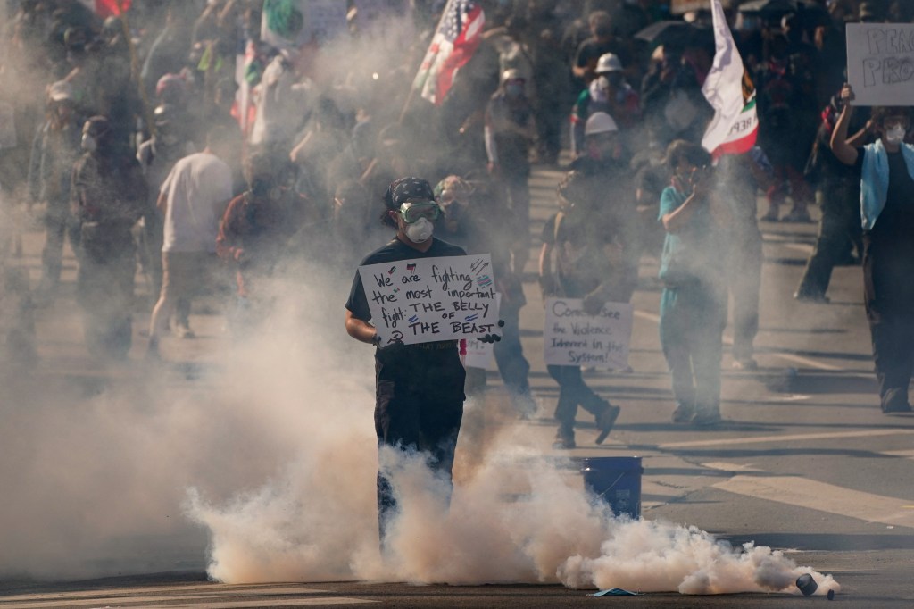 Protestor amid tear gas at a Los Angeles demonstration against federal immigration sweeps.