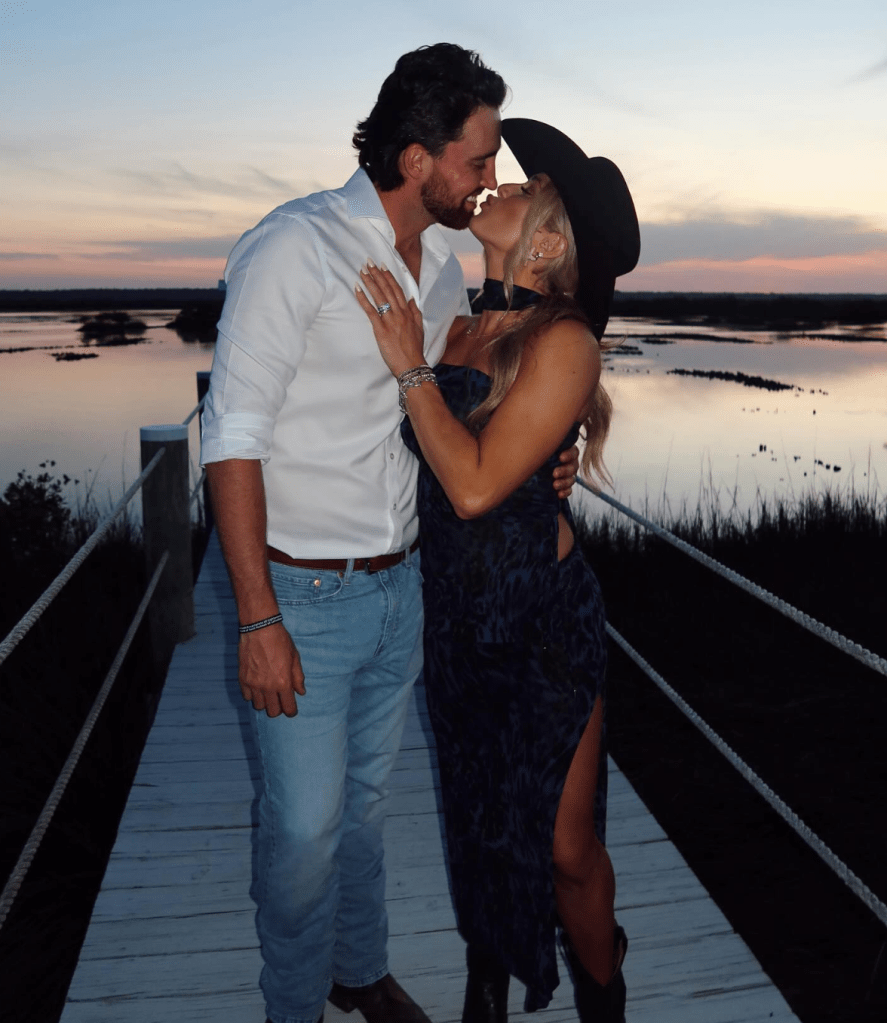 Couple kissing at sunset on a dock.