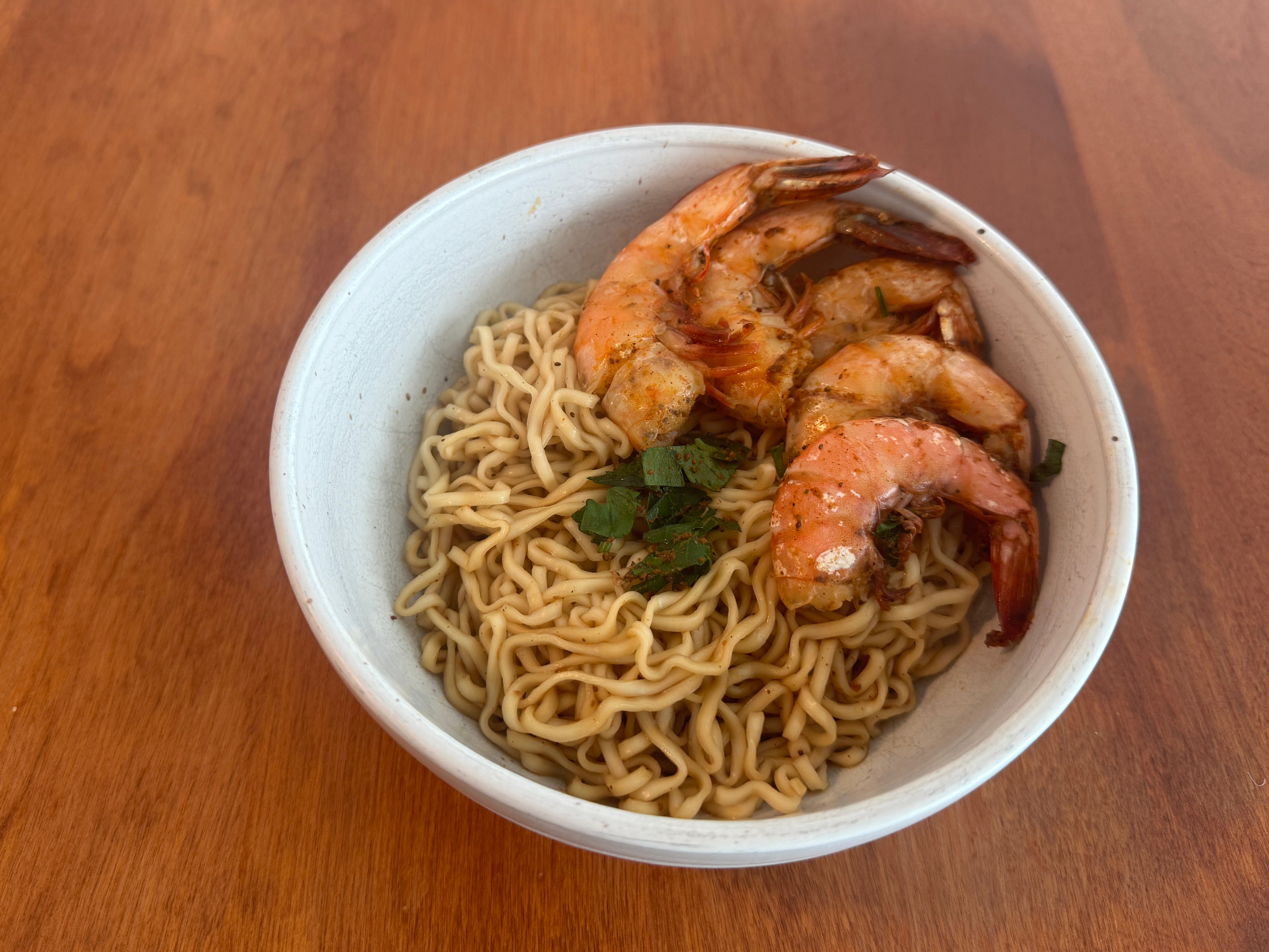 Cooked shrimp on top of noodles in bowl