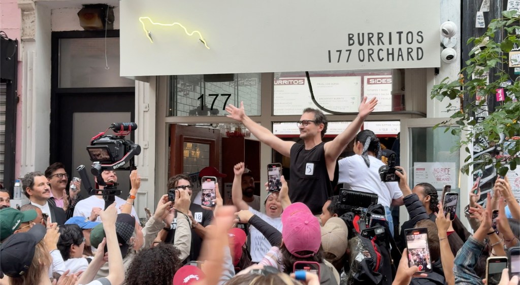 A Pedro Pascal look-alike contest winner being celebrated by a crowd.