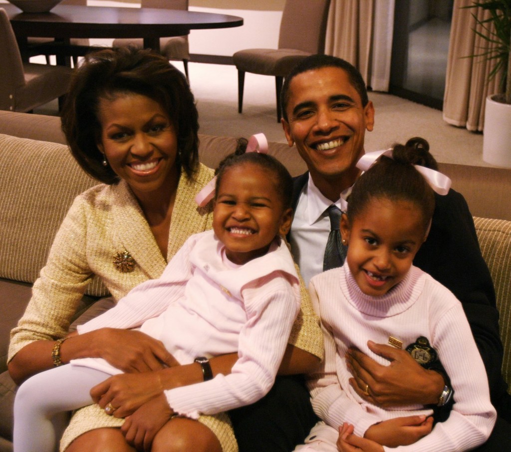 Michelle Obama posing with Barack Obama and their kids.