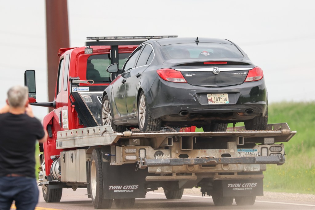 A car getting towed away from a search area in Sibley County on June 15, 2025.