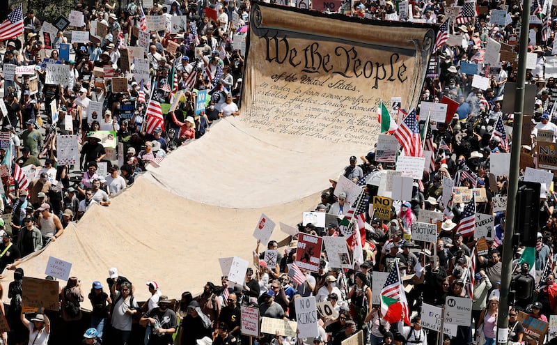 Protesters carry a banner representing the Preamble to the U.S. Constitution in downtown Los Angeles during an anti-Trump "No Kings Day" demonstration on June 14, 2025.