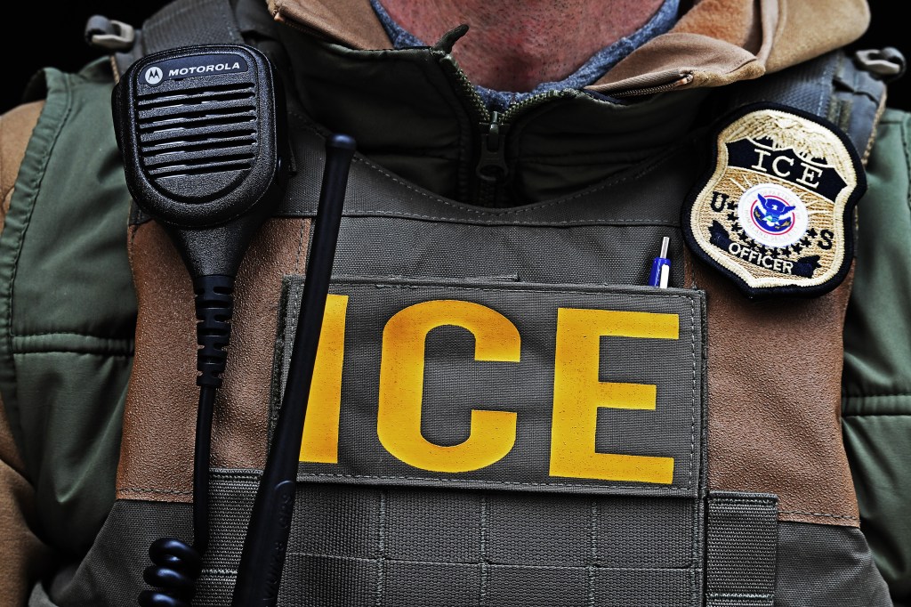ICE officer's vest with radio and badge.