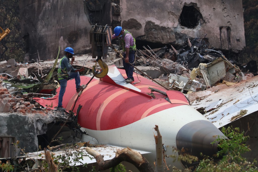 A crane retrieves part of the fuselage of the Air India Boeing 787 on June 14, 2025 in Ahmedabad, India.