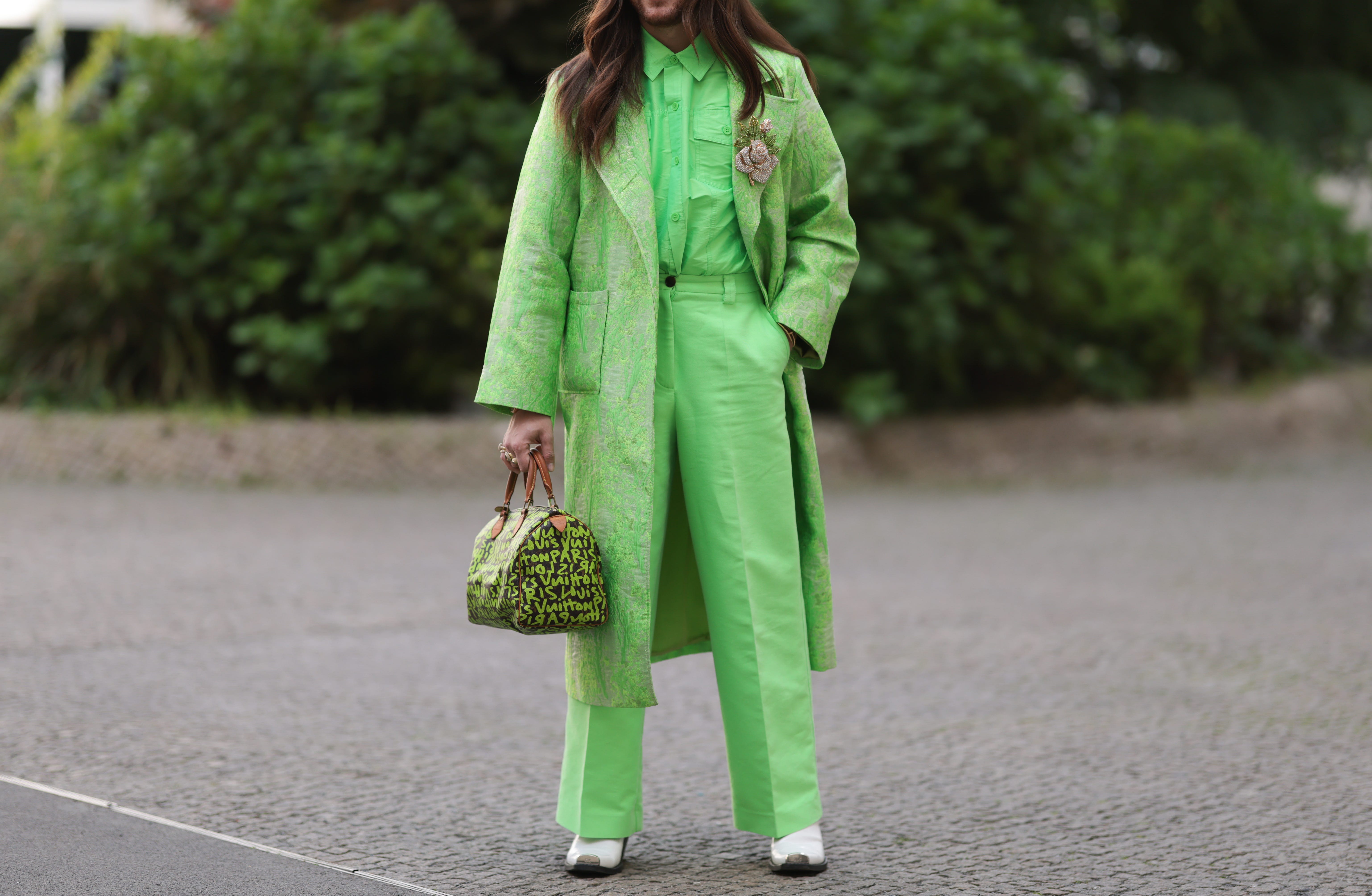 Person wearing neon-green suit with neon-green bag