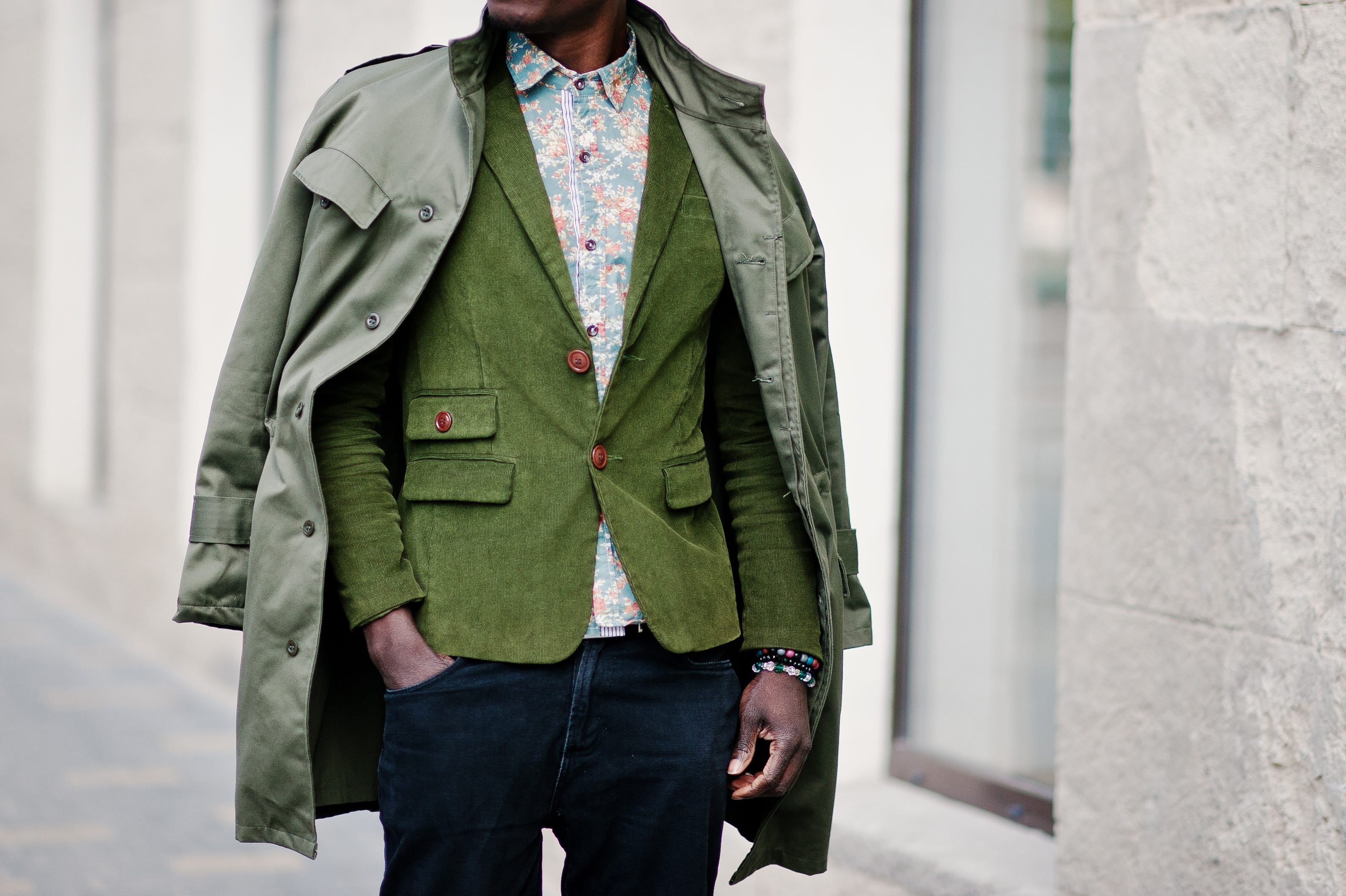 Man wearing. green jacket, floral button down, jeans