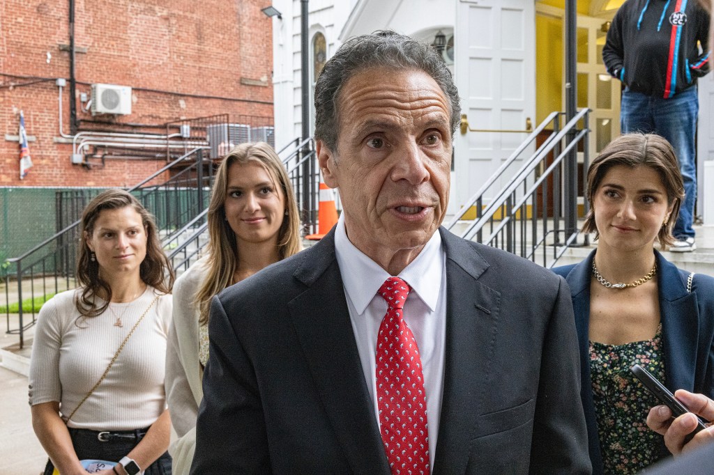 Andrew Cuomo with his daughters speaking at a church.