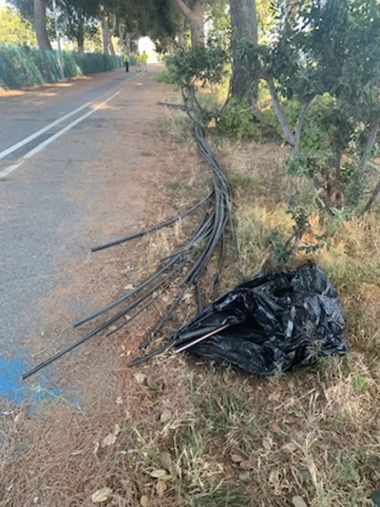 Cut fiber optic cables lying on the ground near a road.