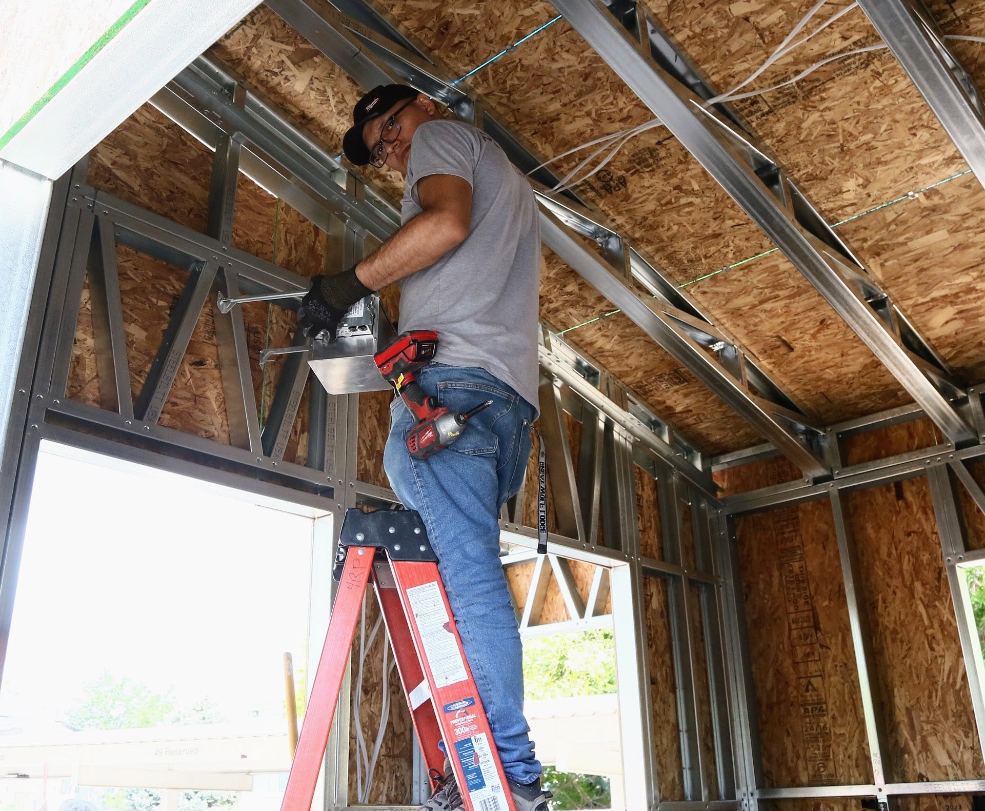 A builder assembling a Hapi Homes unit.