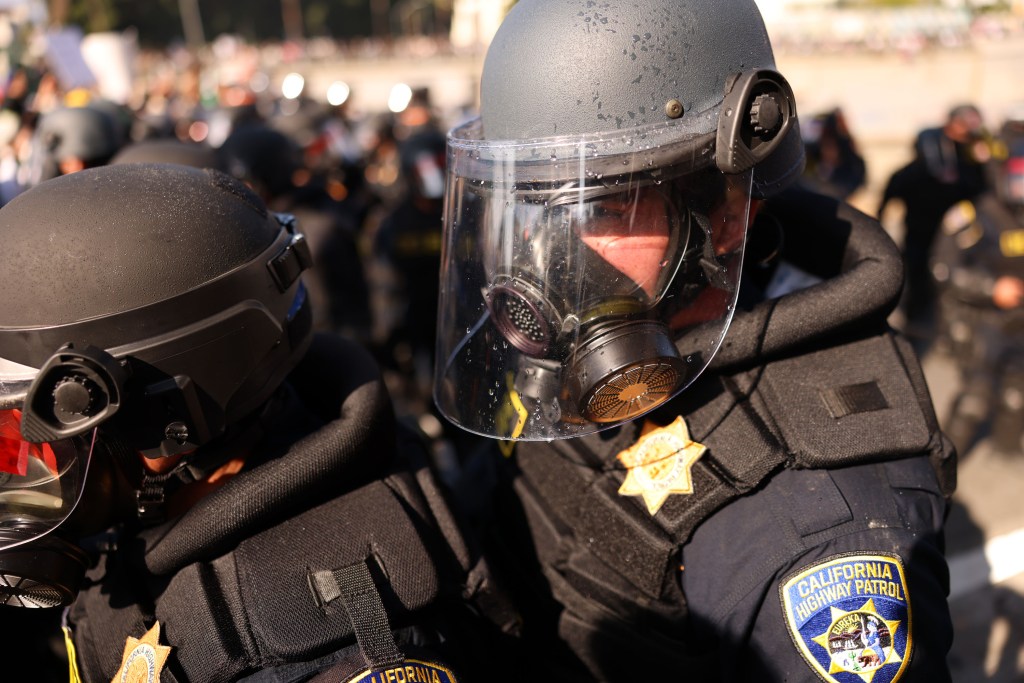 Close-up of California Highway Patrol officers in riot gear at a protest.