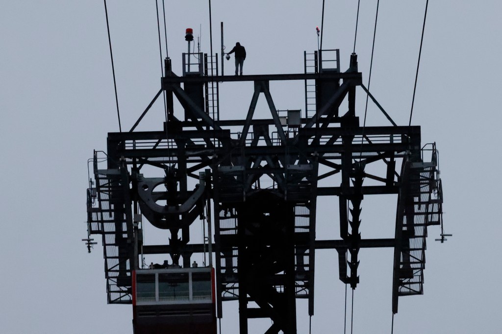 The 20-year-old suspect was seen nonchalantly walking back and forth along the gangway of the tramway's 250-feet-tall support tower on the Manhattan side