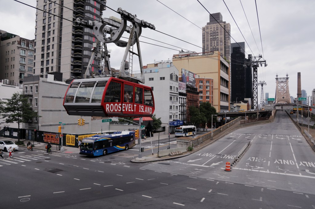 People ride the tramway from Roosevelt Island as a rally in support of priority boarding for Roosevelt Island residents and workers takes place at Tramway Plaza in New York City on June 08, 2025.
