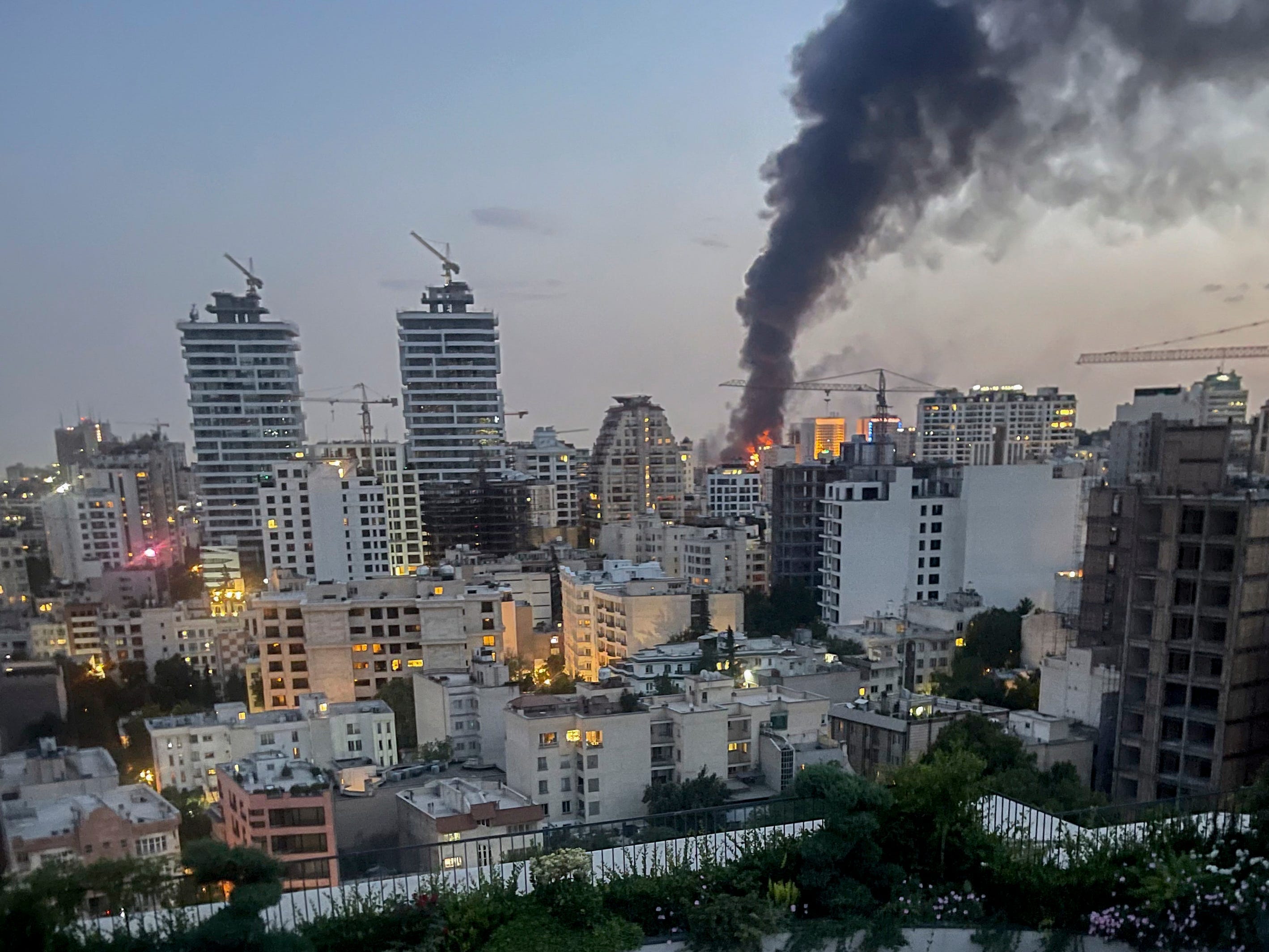 Smoke rises from the rubble of an Iranian state media building in Tehran after an Israeli airstrike on June 16.