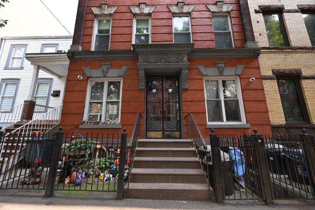 Exterior of a brick house with a collection of figurines displayed on the windowsill.