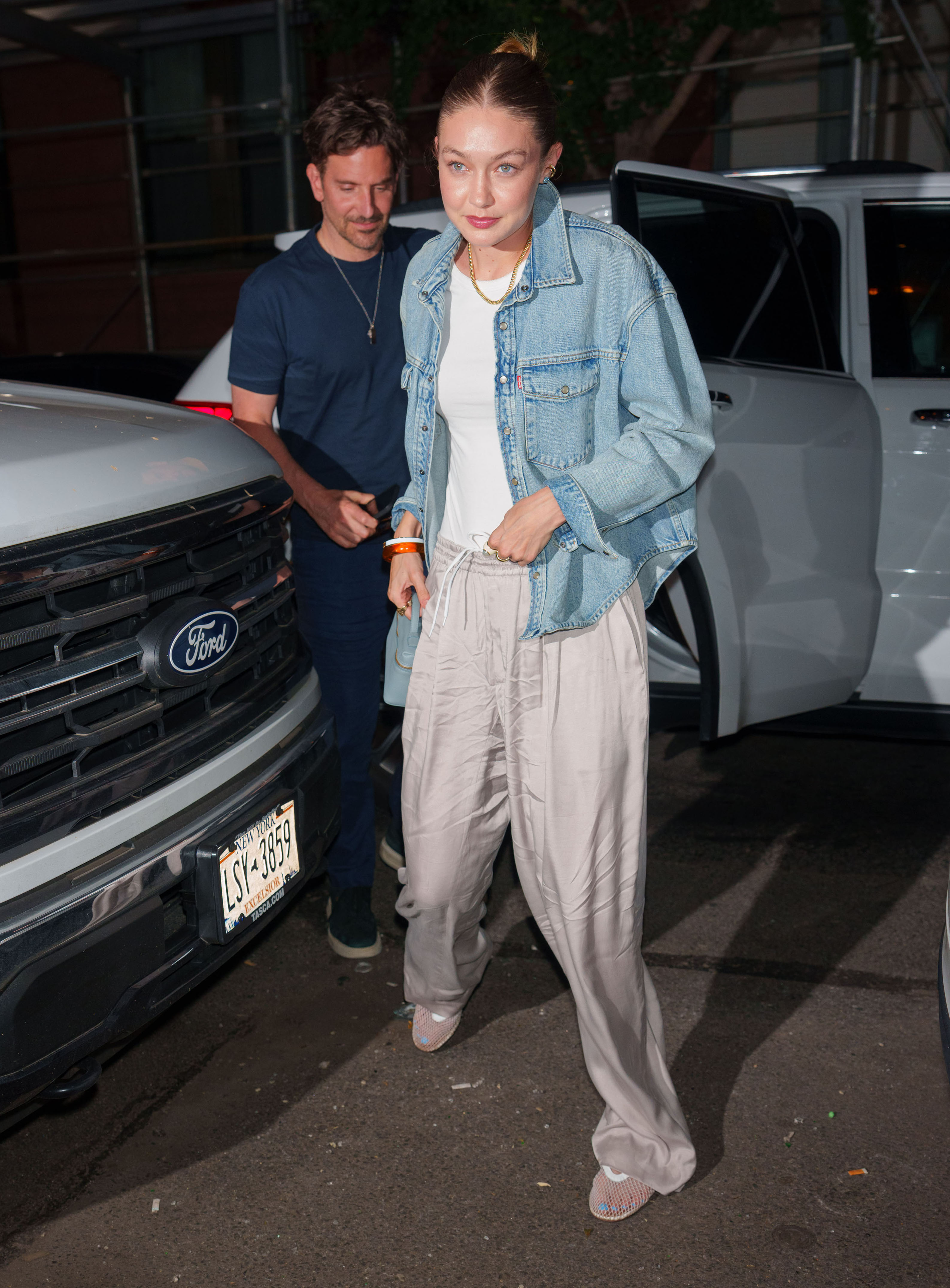 Bradley Cooper and Gigi Hadid outside a vehicle. 