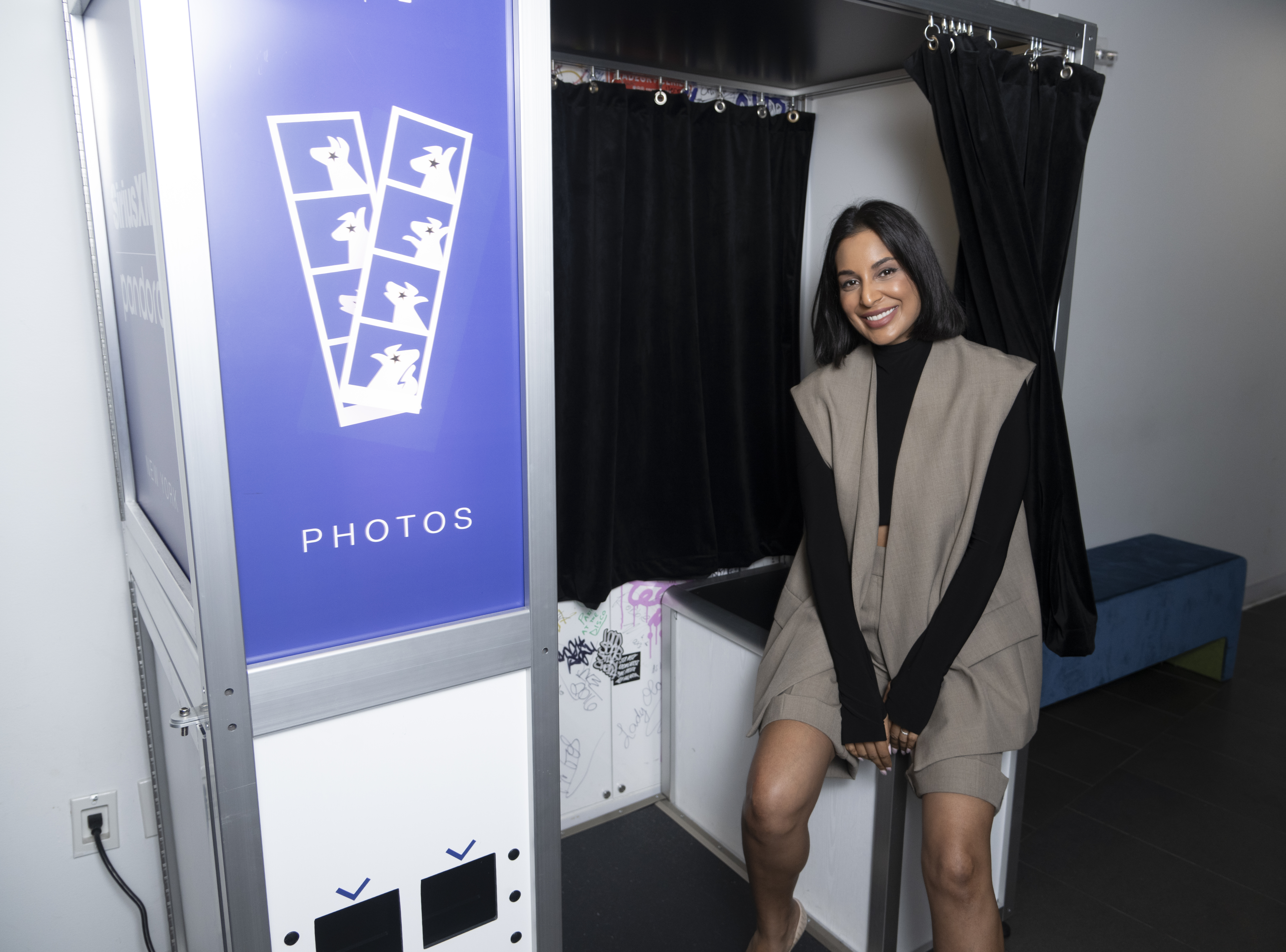 Jessel Taank sits outside a photo booth. 