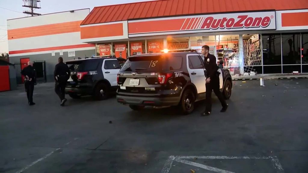 Police officers at a ransacked AutoZone store.