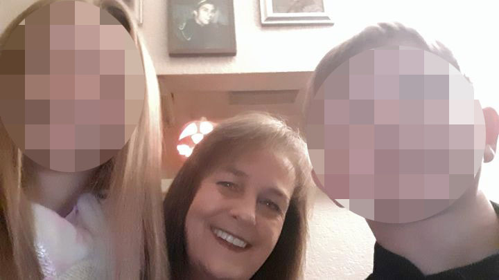 Photo of a woman with two blurred faces of younger people beside her.
