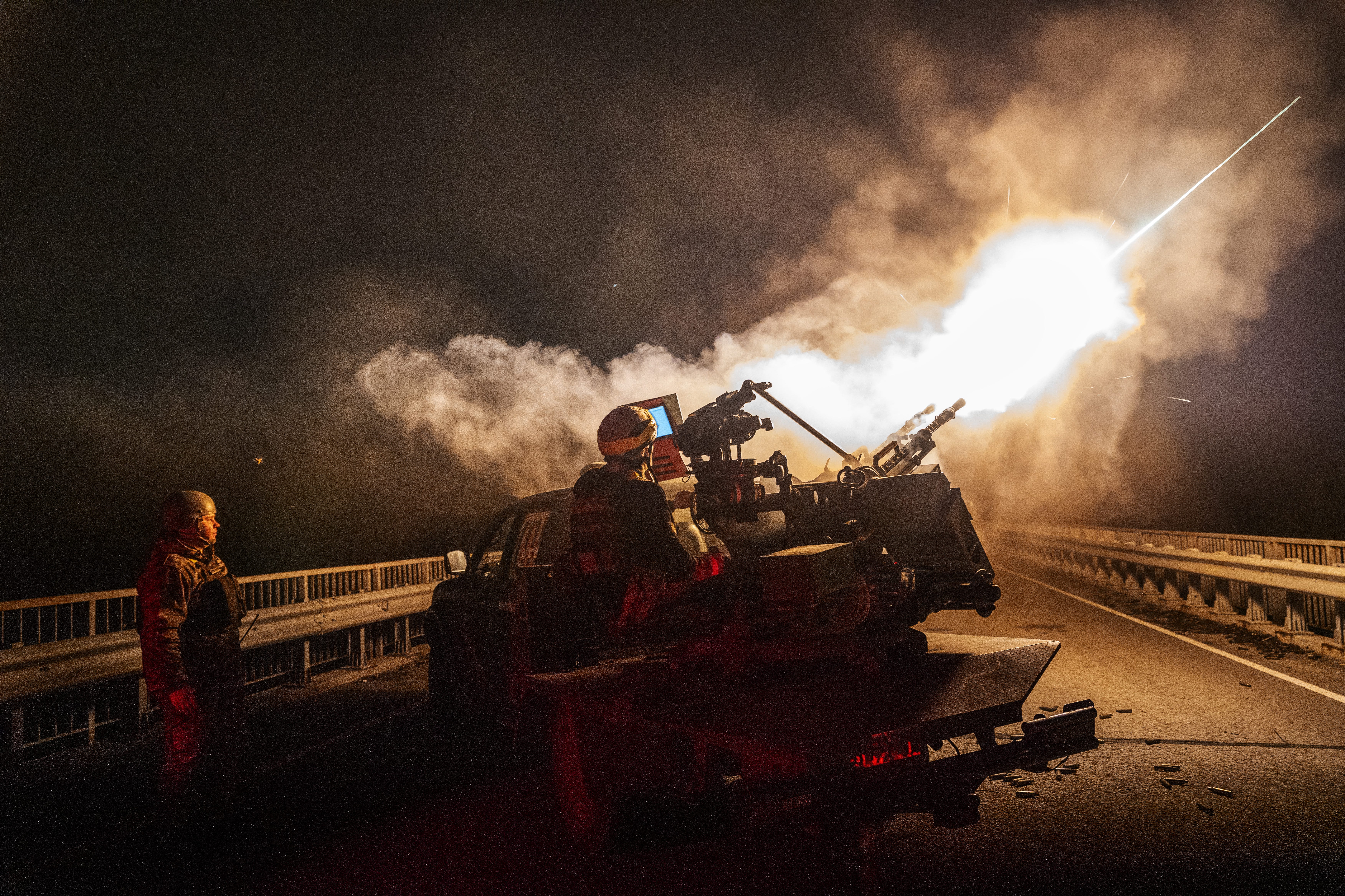 Soldiers from a Ukrainian mobile air defense group fire a machine gun at Russian drones.