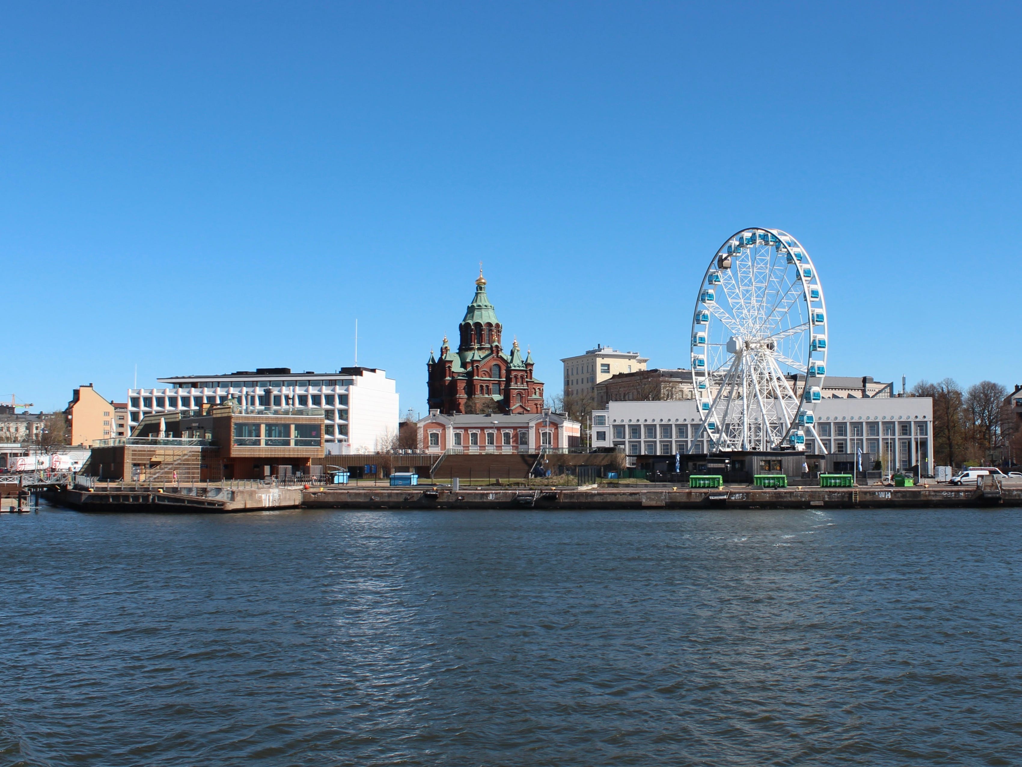 A Ferris wheel and buildings near water.