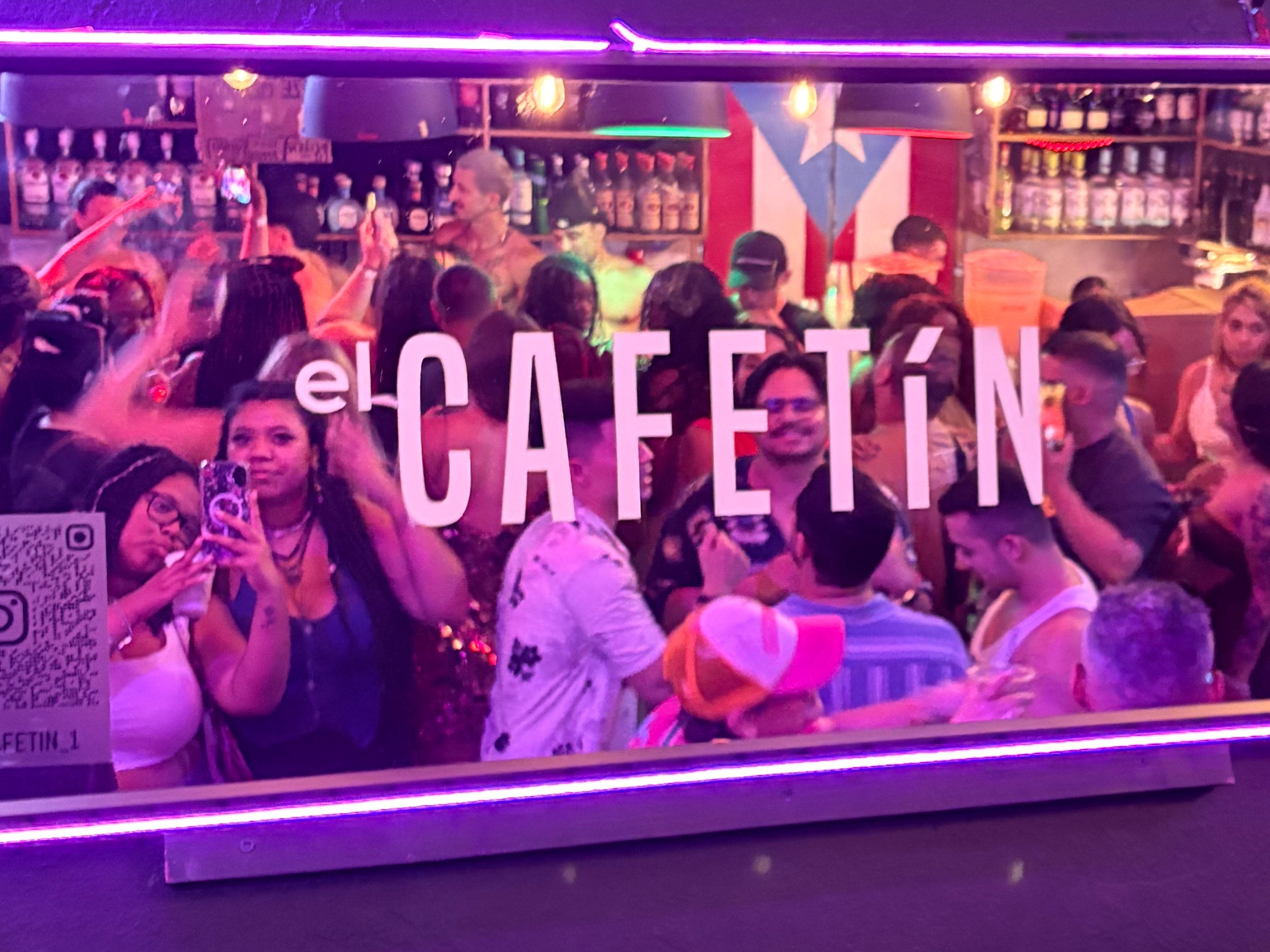 The author and her sister taking a picture in a mirror at El Cafetín. Lots of other patrons are around them.