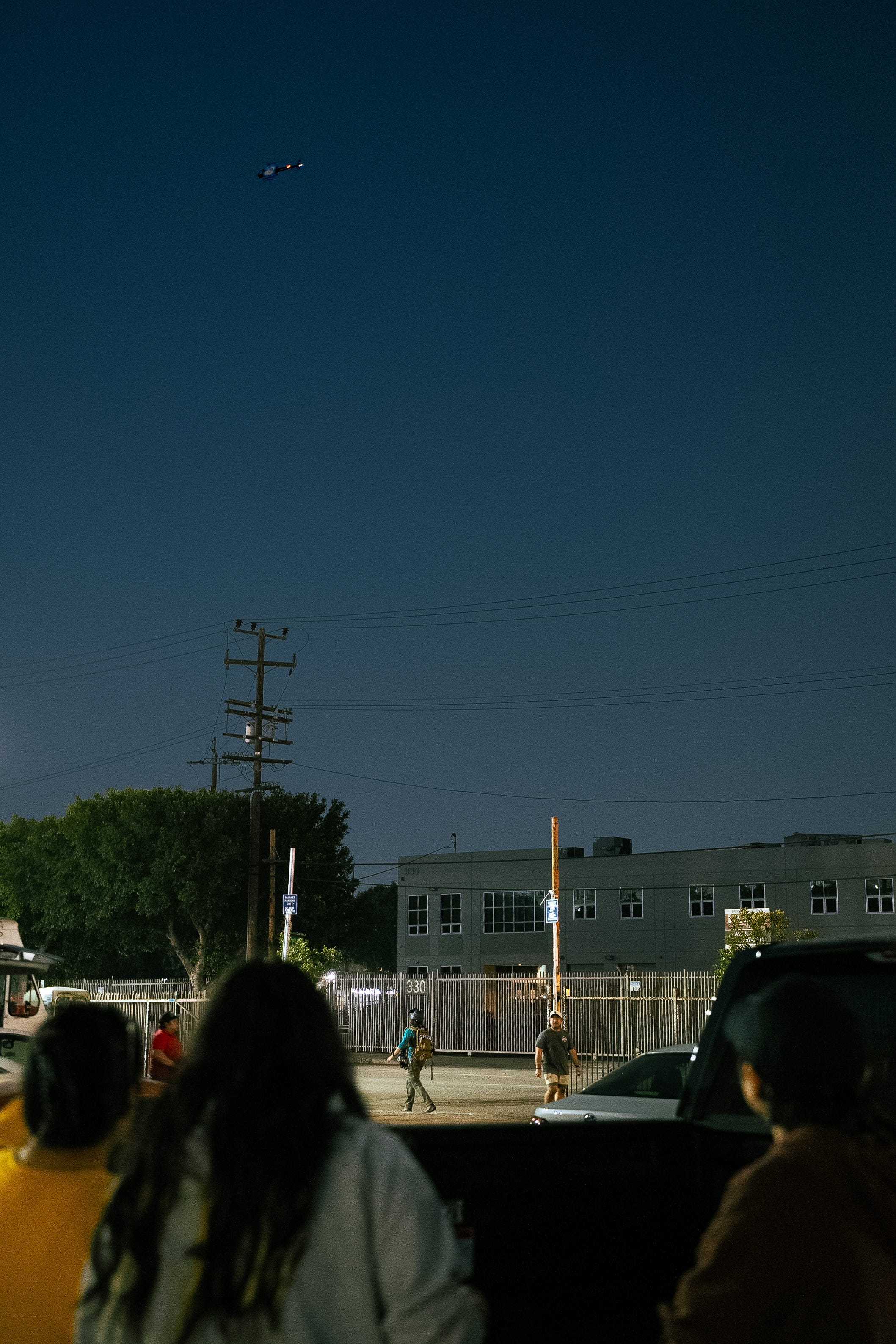 People look up in Downtown LA at the helicopter in the sky