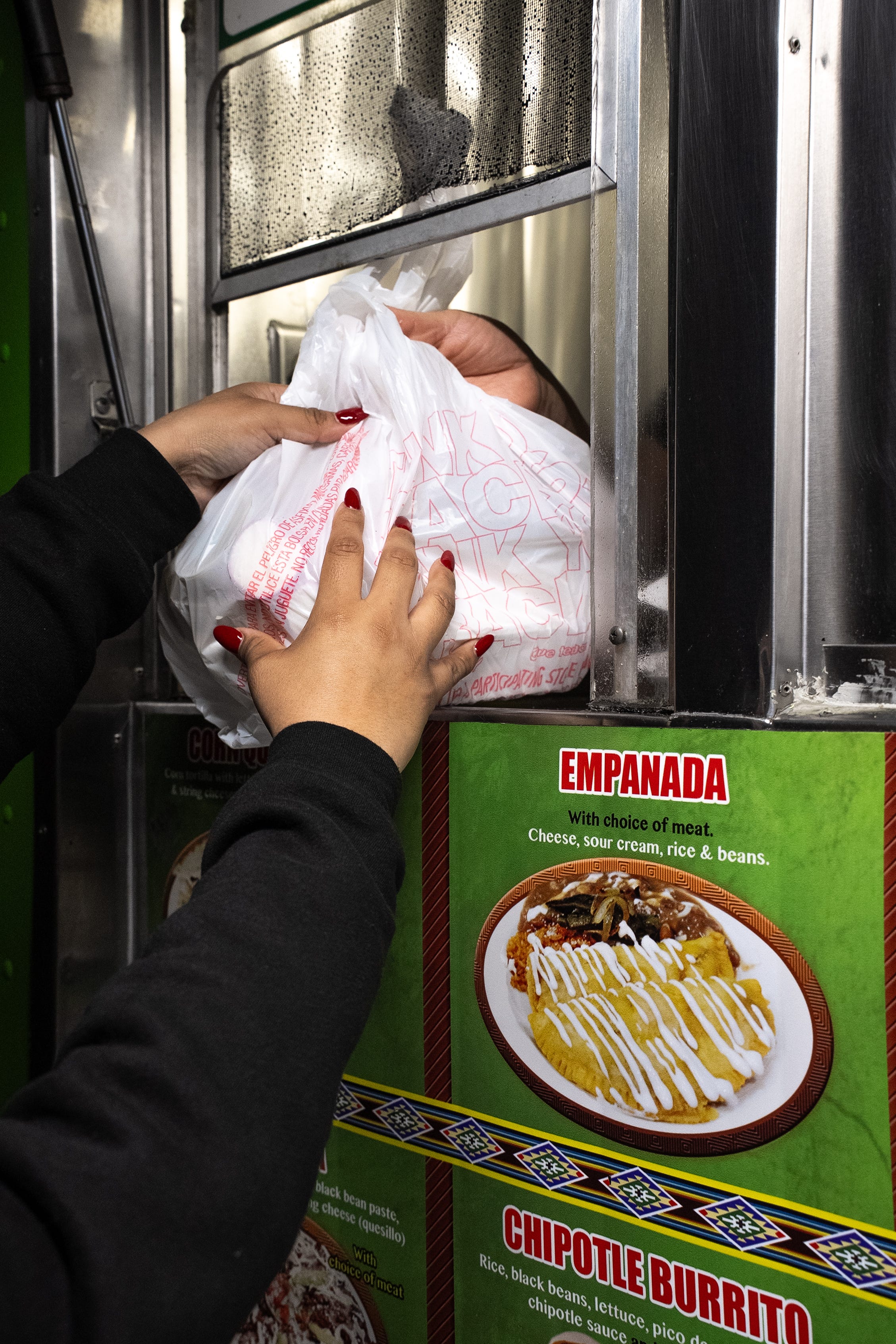 a customer picks up food from a taco truck