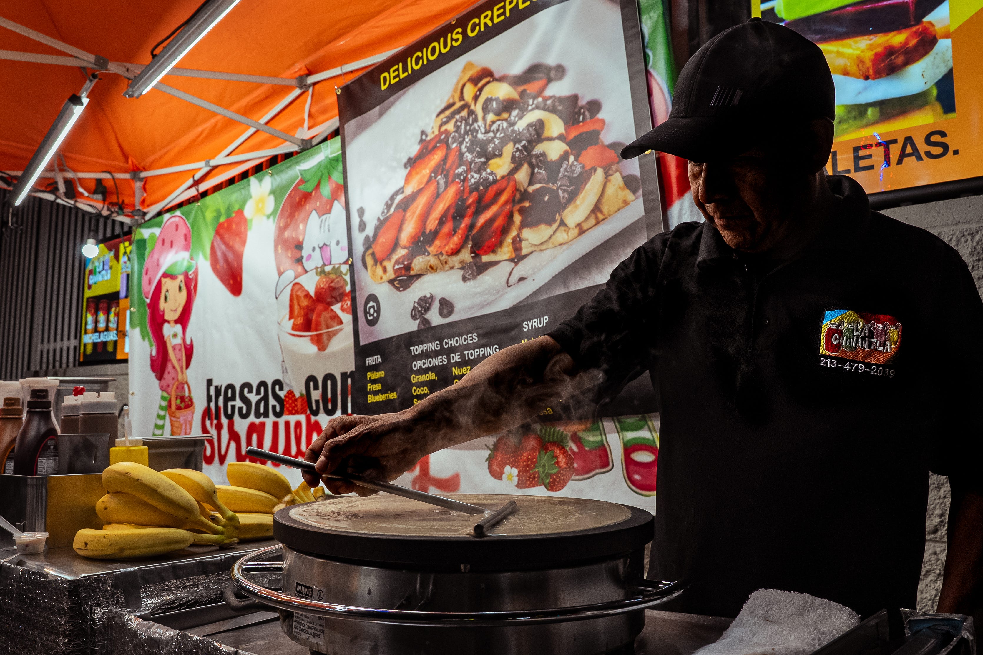 A man makes a crepe using a batter