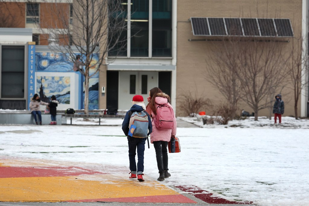 Students walk to school in the snow.