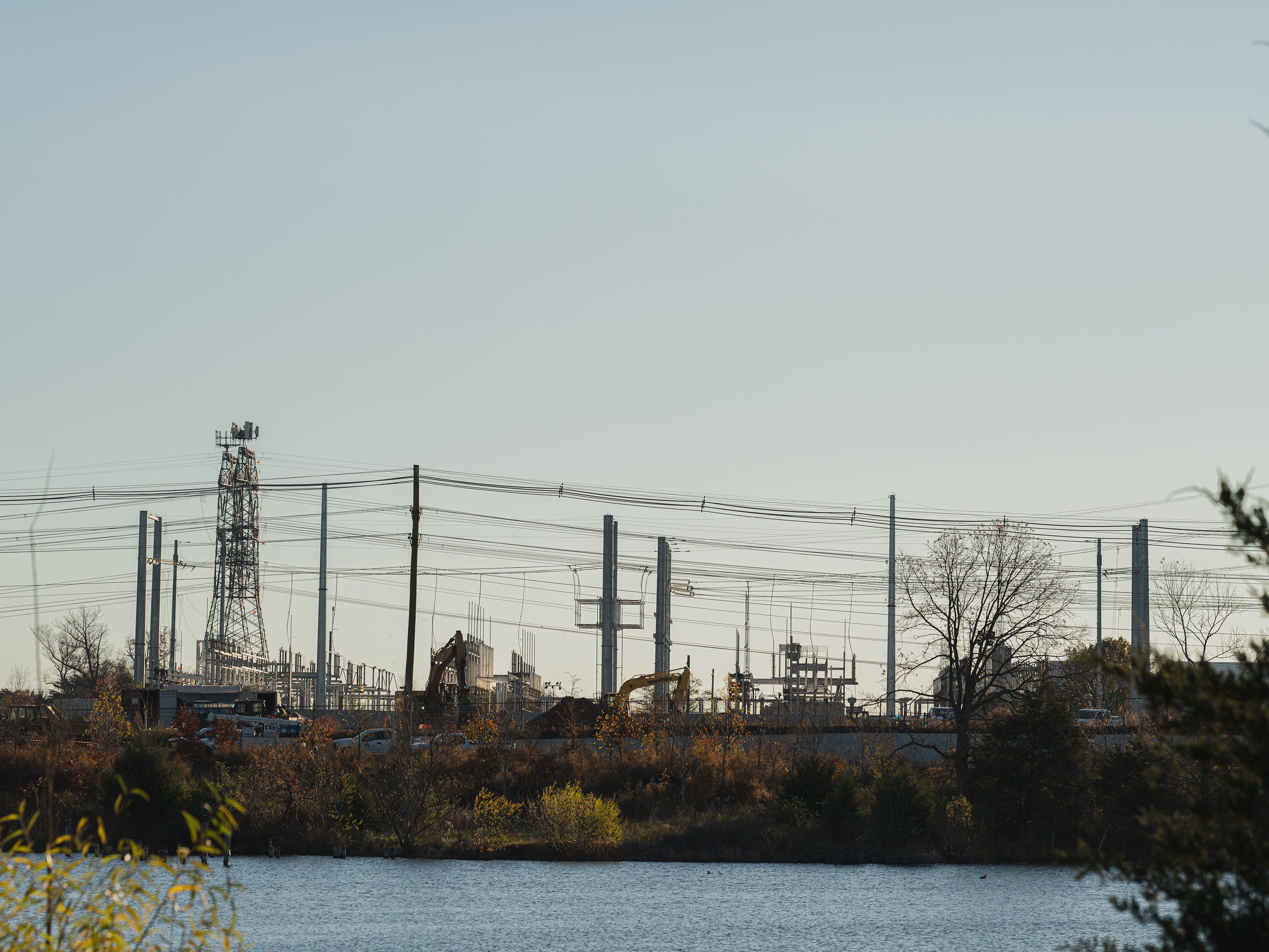 Power lines next to a river.
