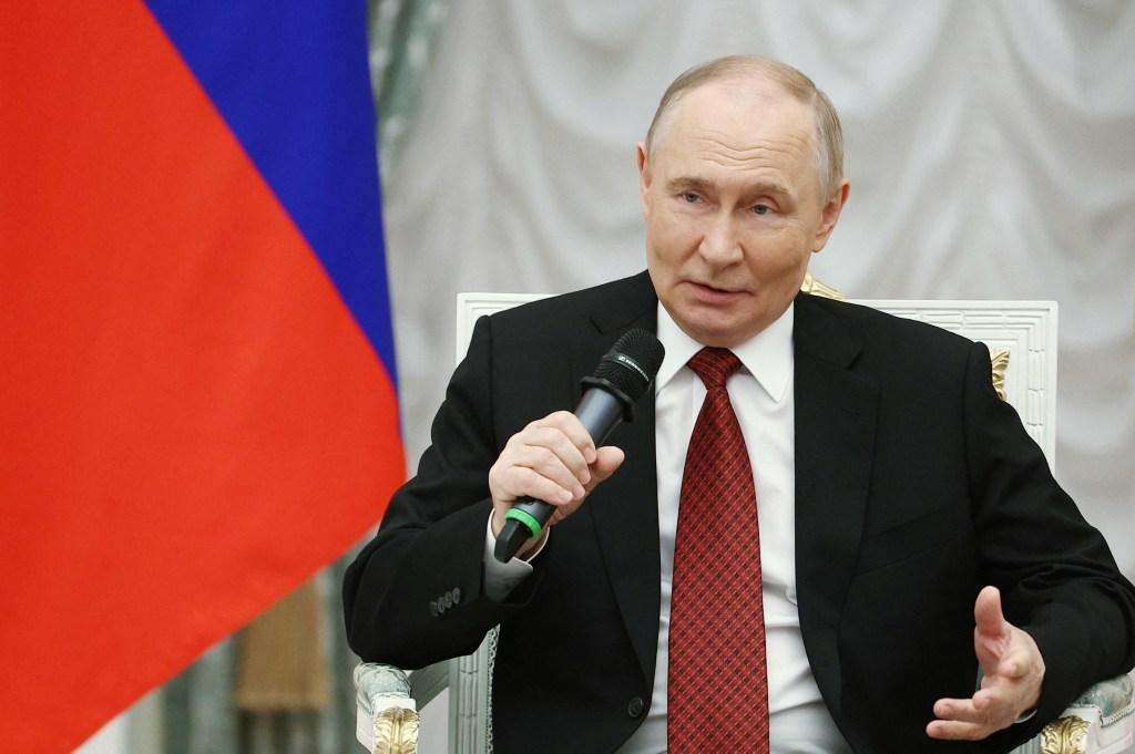Vladimir Putin speaking into a microphone.