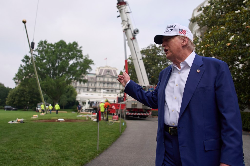 Donald Trump speaking near the White House, while a flagpole is being installed.