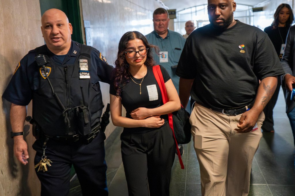 Stephanie Rodas, daughter of victim Diana Agudelo, escorted by a police officer and a man.