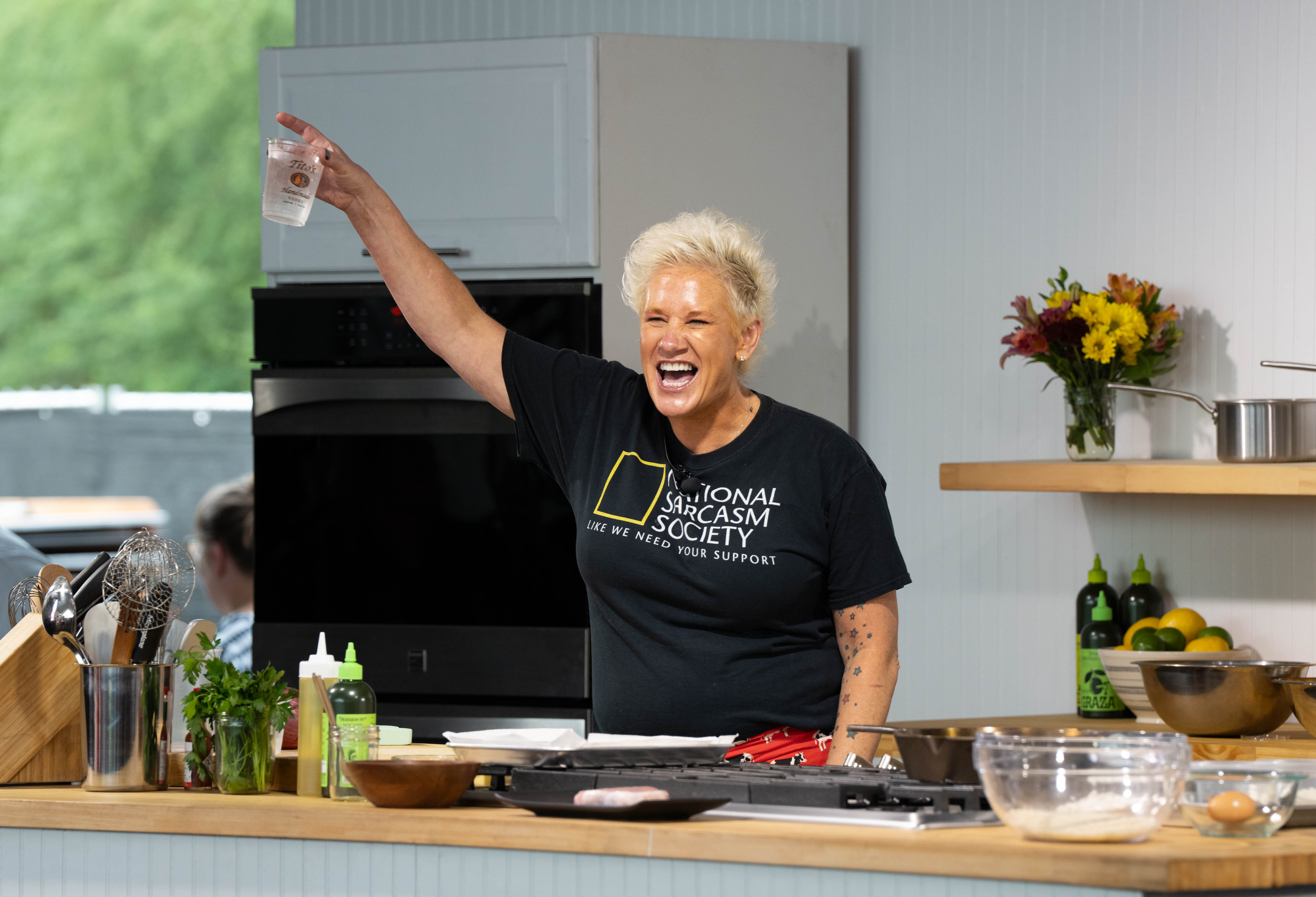 Anne Burrell smiles in a kitchen. 