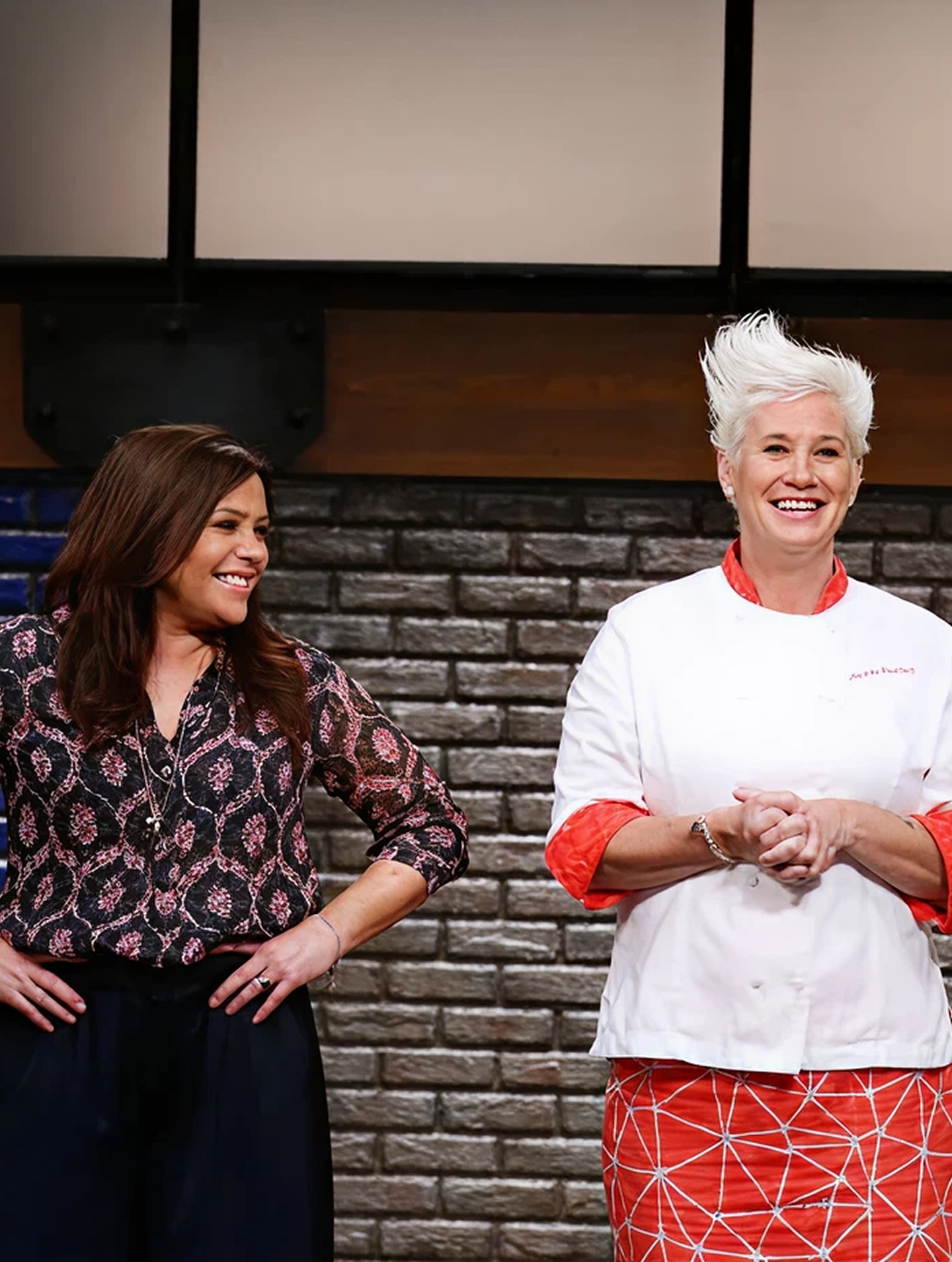 Rachel Ray and Anne Burrell smile onstage. 