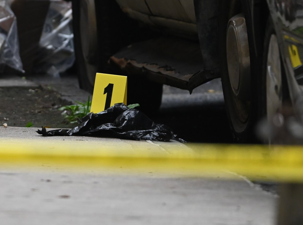 An evidence marker is placed near the vehicle where Bautista was shot.